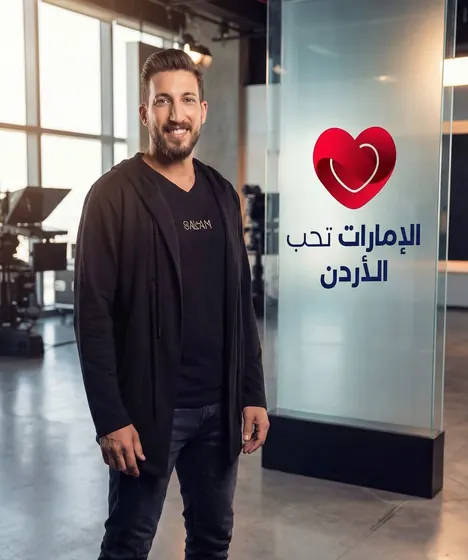 Ahmed beside the Emirates Loves Jordan logo